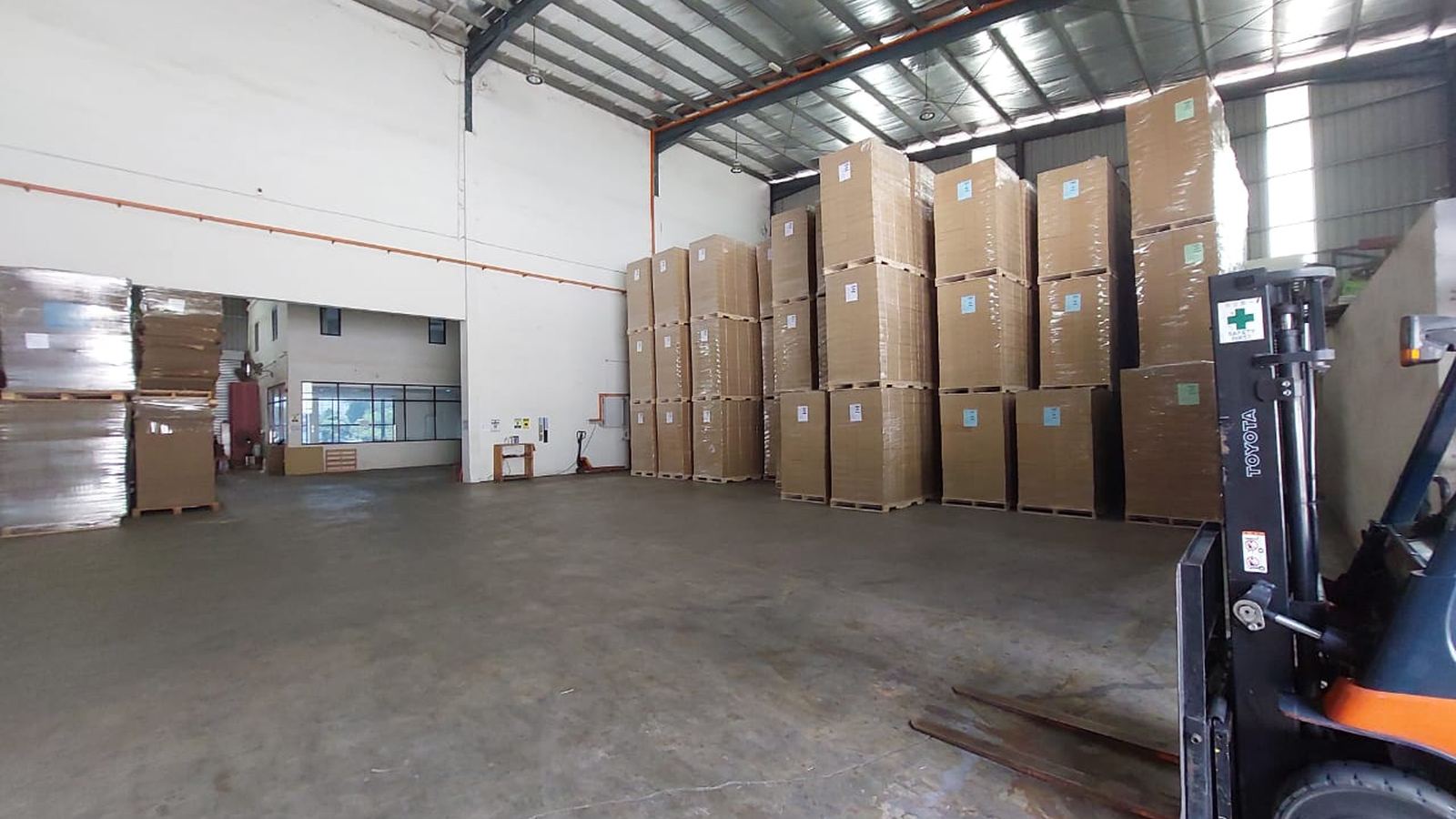 A forklift parked beside stacked cartons in the Johor Bahru bay.